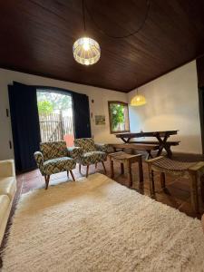 a living room with a couch and a table and chairs at Casa Baleia Lagoa in São Pedro da Aldeia