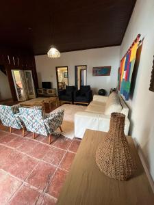 a living room with a bed and a table at Casa Baleia Lagoa in São Pedro da Aldeia