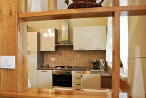 a kitchen with white cabinets and a stove top oven at Garden House in Matulji