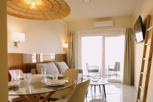 多列毛利诺斯Apartamentos Buendia Suites - Torremolinos Centro的一间带桌子的餐厅和一间客厅