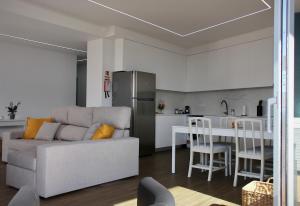 a living room with a couch and a kitchen at Like Home II - casa espaçosa com 3 quartos e vista mar in Funchal