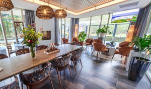 a dining room with a large wooden table and chairs at Duinhotel Zomerlust in Zoutelande
