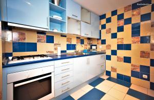 une cuisine avec des placards blancs et du carrelage bleu et jaune dans l'établissement Luxury 2-bed apartment with huge pool - Albufeira, à Albufeira