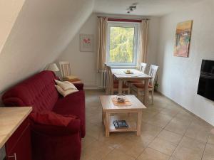 ein Wohnzimmer mit einem roten Sofa und einem Tisch in der Unterkunft Ferienwohnung Mattke in Heiligendamm