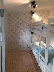 sypialnia z dwoma łóżkami piętrowymi i sufitem w obiekcie Cozy guesthouse by the sea w mieście Saltsjöbaden