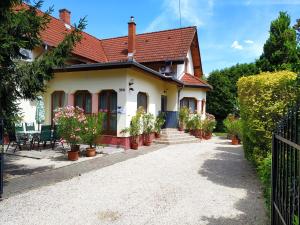 a house with potted plants in a driveway at Norbert Vendégház in Balatonszárszó