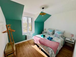 Un dormitorio con una cama y una pared verde. en KIKOR, belle vue sur le Loiret, en Saint-Pryvé-Saint-Mesmin