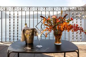 a table with a vase and flowers on a balcony at Il Belvedere in Torno