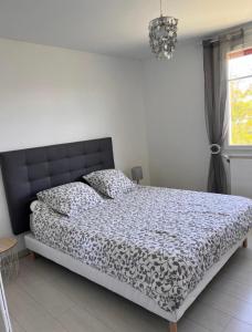 a bedroom with a bed with a black and white comforter at appartement bayonne in Bayonne