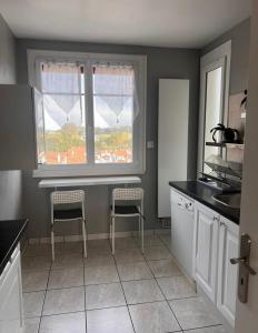 a kitchen with two chairs and a window at appartement bayonne in Bayonne