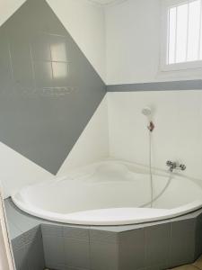 a white bath tub in a bathroom with a window at Tissianna Villa Confort de Grand Anse in Petite Île