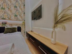 a bedroom with a bed and a vase with a plant at The Pest Garden Condo A in Budapest +8 photos