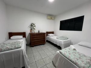a room with two beds and a tv on the wall at Casa Limoeiro Tibau do Sul in Pipa +27 photos