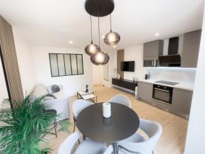 kuchnia i salon ze stołem i krzesłami w obiekcie Appartement Étoilé, Plage, Parking, WiFi, Calme w mieście La Grande-Motte