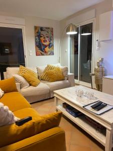 ein Wohnzimmer mit einer Couch und einem Couchtisch in der Unterkunft Villa 49 Hameau des Greens in Sainte-Maxime