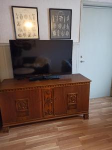 a flat screen tv sitting on top of a wooden cabinet at Gästis lägenhet Örkelljunga in Orkelljunga