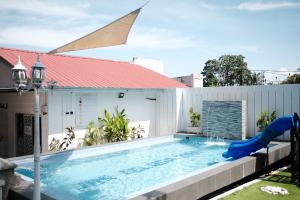 an outdoor swimming pool with a slide and a playground at Jas Telaga Inn Homestay in Teluk Mas