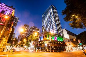 a city street at night with a tall building at ibis Styles Brisbane Elizabeth Street in Brisbane
