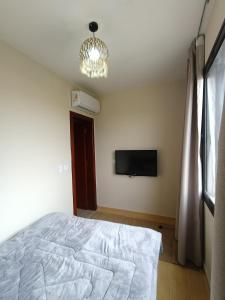 Un dormitorio con una cama y un televisor de pantalla plana. en Azha ain sokhna, en Ain Sokhna