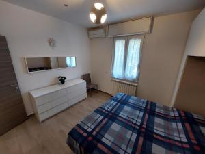 a bedroom with a bed and a dresser and a window at Al Crocevia in Bologna