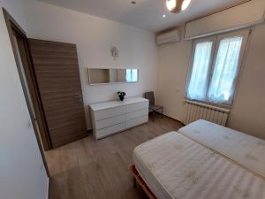a bedroom with a bed and a desk and window at Al Crocevia in Bologna