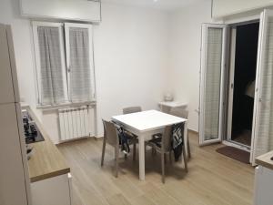 a white table and chairs in a kitchen with windows at Al Crocevia in Bologna