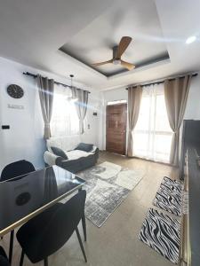 un soggiorno con un divano e un ventilatore a soffitto di Hero House a Pooc