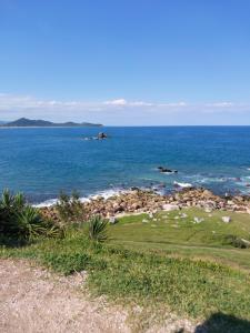 a golf course with the ocean in the background at Apartamento em Imbituba, praia da Vila in Imbituba