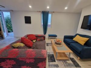 a living room with a couch and a table at maison de la bruyère in Les Authieux-sur-Calonne