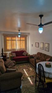 ein Wohnzimmer mit Sofas und einem Tisch und einer Couch in der Unterkunft Localização Imbatível! A 98m da Praia do Forte com Conforto, Ar-Condicionado e Estacionamento! in Cabo Frio