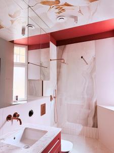 a white bathroom with a sink and a shower at Kliniczna Apart in Gdańsk