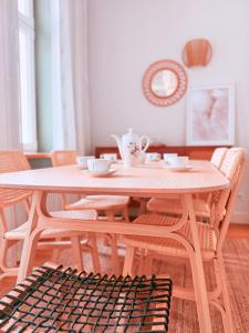 a wooden table and chairs with cups and saucers on it at Kliniczna Apart in Gdańsk