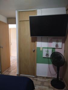 a flat screen tv hanging from a wall in a room at La casita de jo in Cartagena de Indias +5 photos