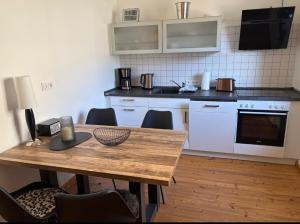 a kitchen with a wooden table with chairs and a counter top at Ferienwohnung EG AusZeit in Bad Bertrich