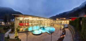 a large building with a swimming pool in front of it at Ferienwohnung EG AusZeit in Bad Bertrich