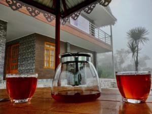 a glass jug and two glasses on a wooden table at Payun Homestay in Mirik
