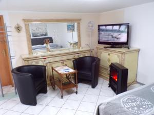 a room with a tv and two chairs and a table and a tvictericter at J.E. Köln in Cologne