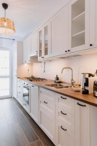 a white kitchen with white cabinets and a sink at HARMONY Apartment - Grand Kristal Residence Bucharest in Bucharest