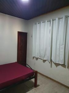 a room with a bed and two windows at Aconchego do Viana in Belém