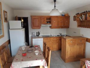 une cuisine avec une table et un réfrigérateur blanc dans l'établissement Studio avec garage privé au pied des pistes, Les Deux Alpes - FR-1-516-82, à Les Deux Alpes 7 autres photos