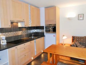 a kitchen with wooden cabinets and a wooden table at Charmant 3 pièces aux Deux Alpes, proche pistes, animaux acceptés - FR-1-516-98 in Les Deux Alpes