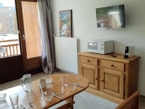Cette chambre dispose d'une table en bois avec des verres. dans l'établissement Studio confortable 4 pers, centre, pistes, balcon - FR-1-516-122, à Les Deux Alpes