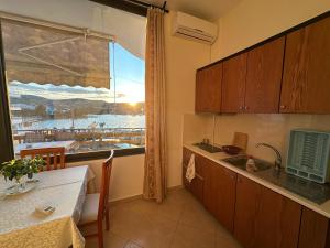 a kitchen with a table and a window with a view at Ion Sea View in Ksamil