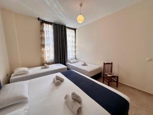 a room with two beds and a chair at Ion Sea View in Ksamil