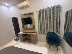 a living room with a tv and a blue chair at Hotel Jawahar Ji Pandya and Restaurant in Khātu