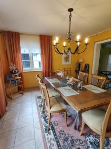 a dining room with a wooden table and chairs at House MayFa in Riedseltz +30 photos