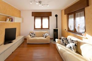 a living room with a couch and a tv at Casa di RoSe - Free private parking in Besano