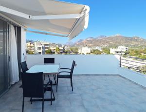 a balcony with a table and chairs and an umbrella at Lux home in central location in Ierapetra