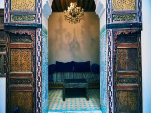 a room with two wooden doors and a couch at Dar Saida in Fez