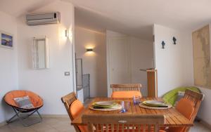 a dining room with a wooden table and chairs at Il Grottino in Stintino